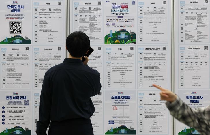 Job seekers look at job postings at a job fair in Seoul, Wednesday. Yonhap