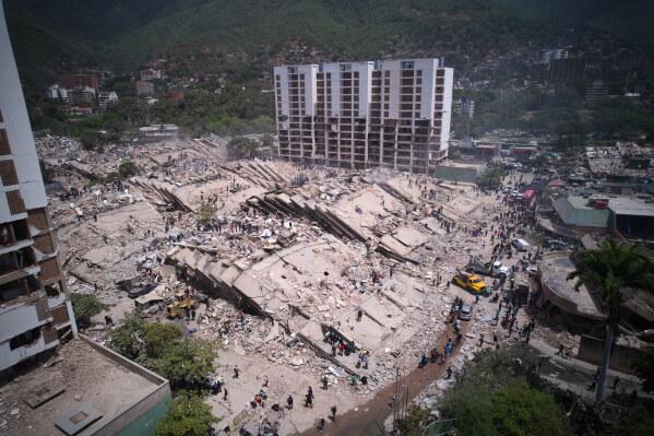 Residents and rescue workers search through the rubble two days after an earthquake struck La Guaira, Venezuela, Friday, June 26, 2026. (AP Photo/Juan Pablo Arraez)