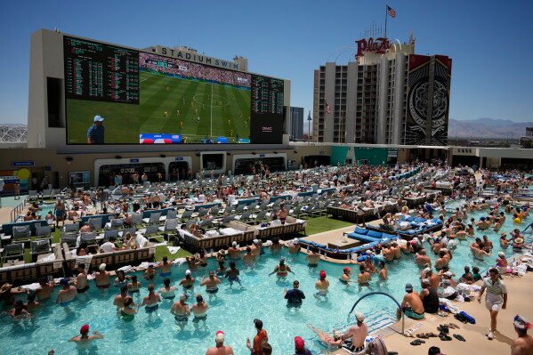 Fans watch a live broadcast of a World Cup soccer match between the U.S. and Australia from a pool at the Circa Resort & Casino, Friday, June 19, 2026, in Las Vegas. (AP Photo/John Locher)