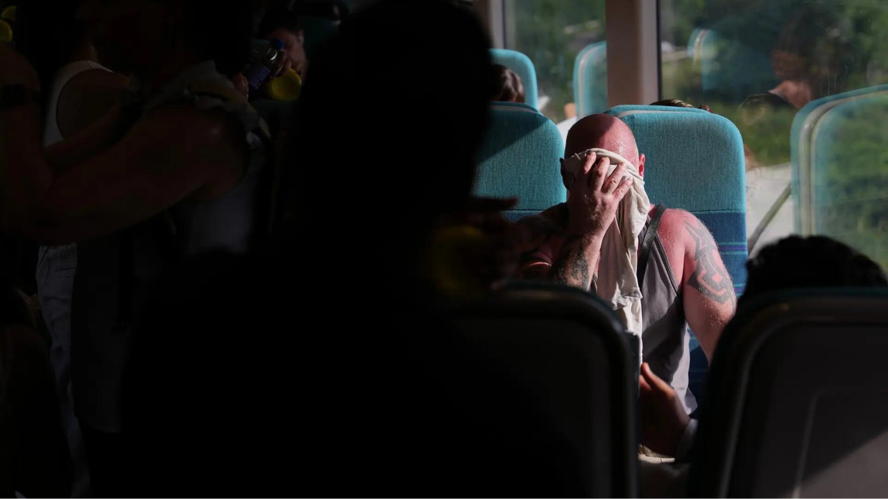 A man on a train wipes sweat from his face on a hot day in London (AP) -