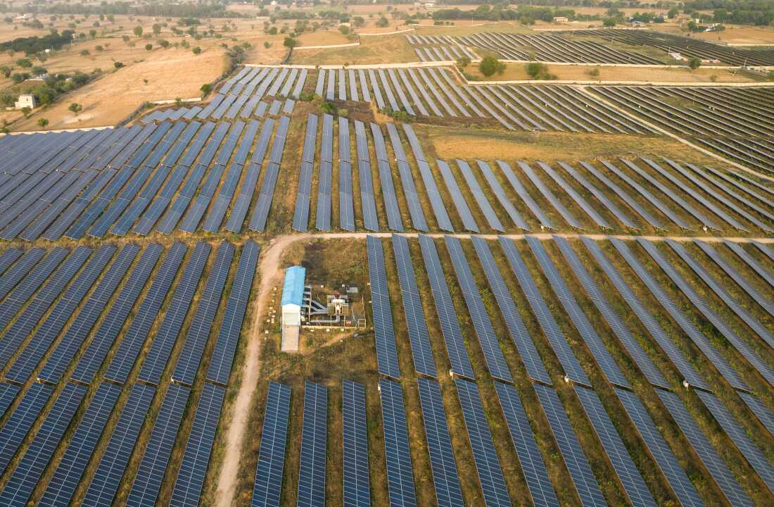 An aerial view of solar panels are seen arranged in rows across a solar power plant in Haryana, India. “What this crisis is doing is kind of creating the need for this energy transition to happen much faster,” says Kaushik Deb who leads the India Team at the University of Chicago’s Energy Policy Institute.