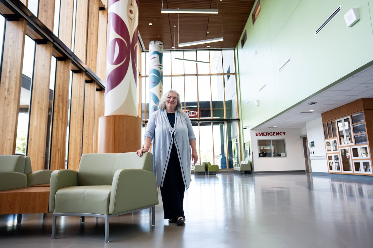 A woman stands in the lobby of a hospital