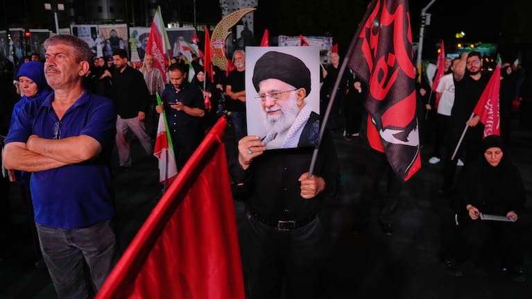 A man holds a poster of the late Iranian Supreme Leader Ayatollah Ali Khamenei in a gathering commemorating him at a square in Tehran.