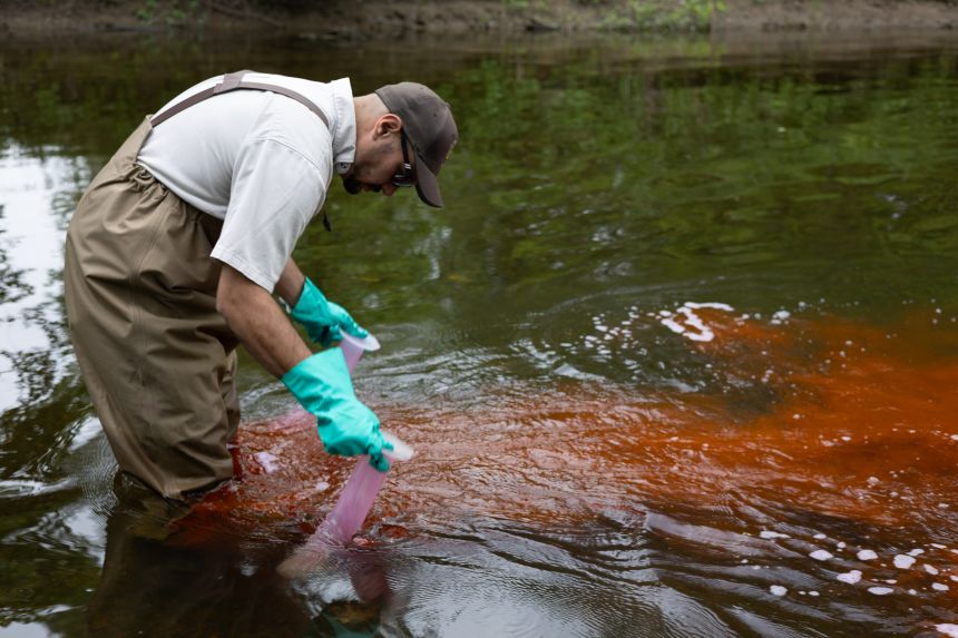 A worker treats water with lampricide, targeting sea lamprey larvae.