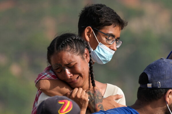 Yolimar Torres, left, cries after she and other family members found her daughter's body, which they recovered themselves from the rubble of a building collapsed by the earthquake in La Guaira, Venezuela, Wednesday, July 15, 2026. (AP Photo/Ariana Cubillos)