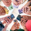 Group of Gen Z friends in a circle holding their phones.