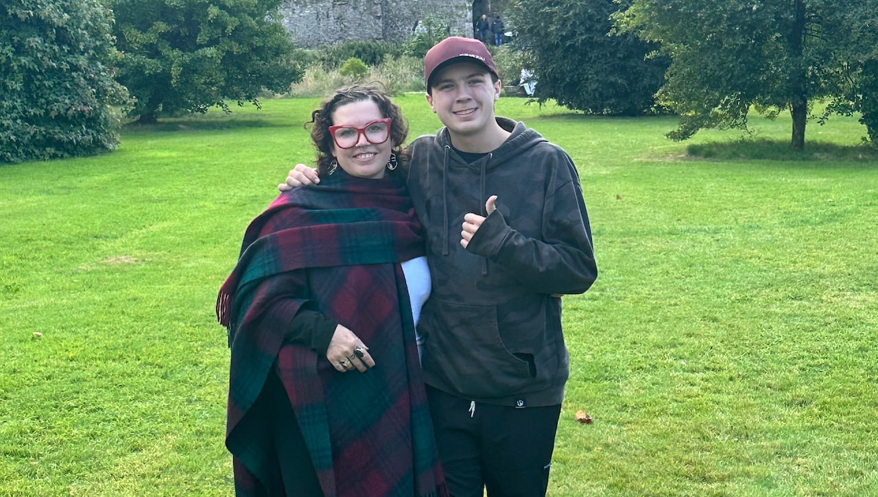 A woman and a youth standing infront of a castle