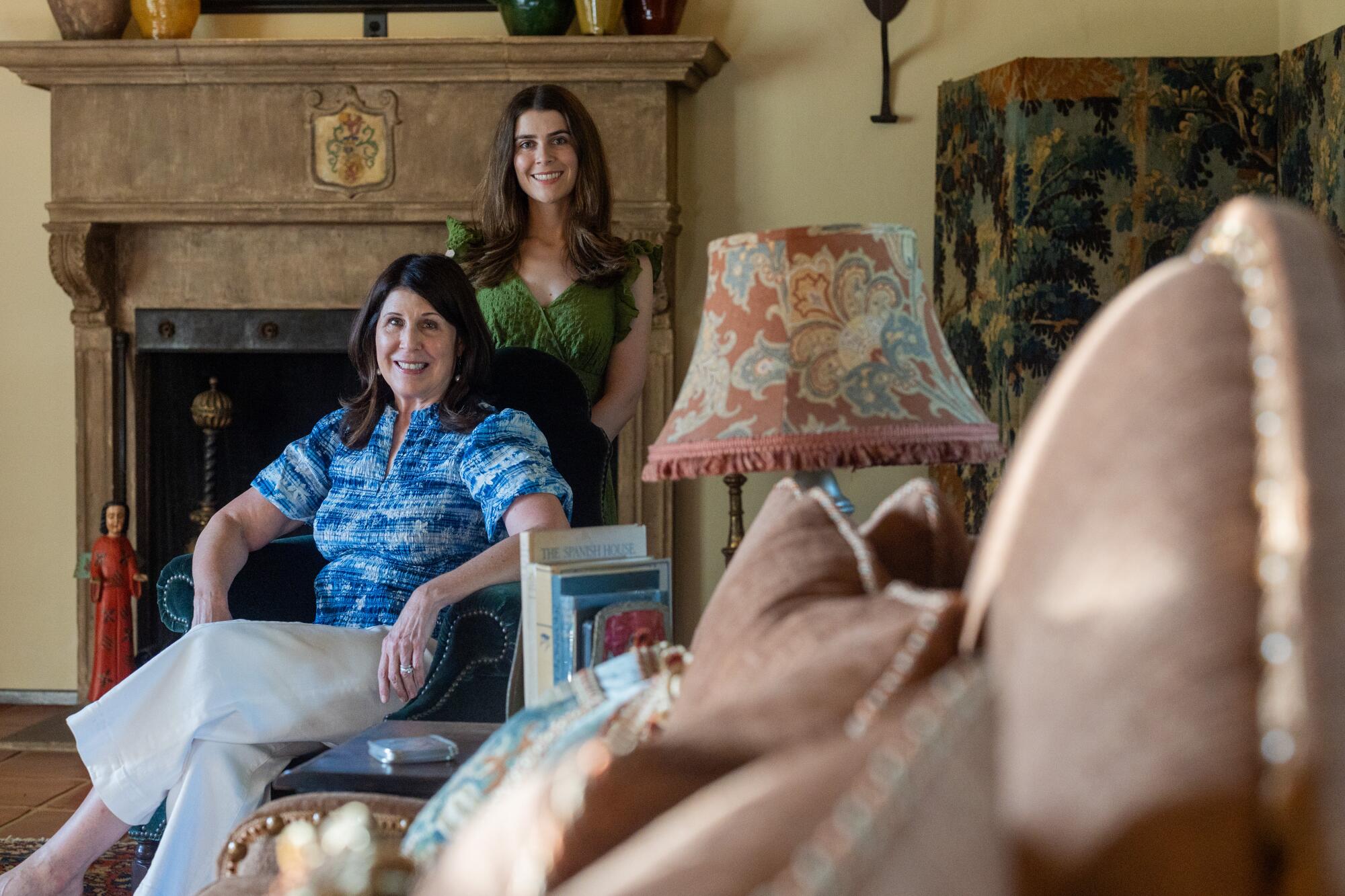Mother and daughter Teri and Julianne Lauenstein sit before the cast stone fireplace in the living room.