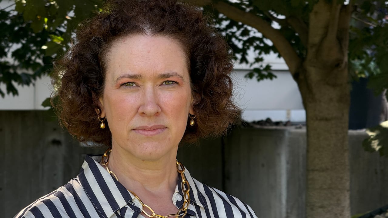 A woman looks into the camera.