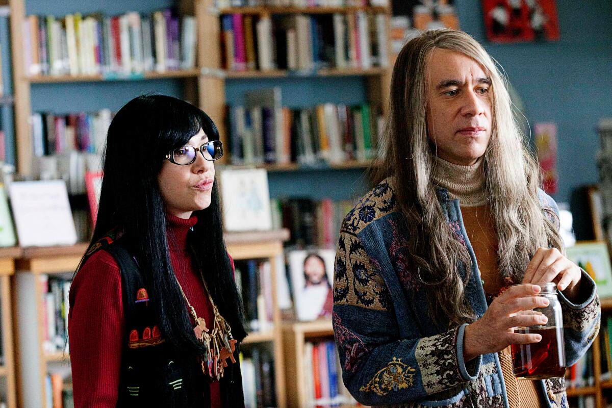 Carrie Brownstein and Fred Armisen in front of shelves of books in a scene from "Portlandia."