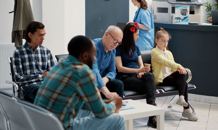 Patients waiting in a hospital lobby for their medical appointments, revealing a common hidden side of hospitals.