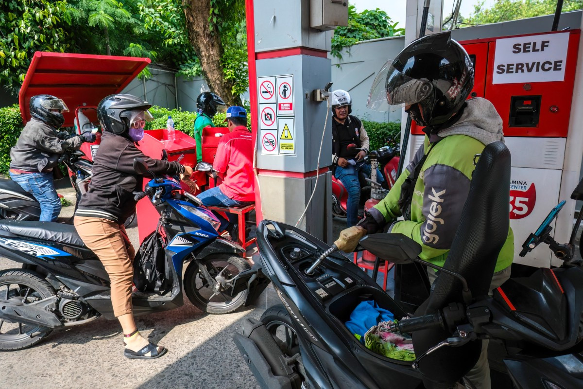 Motorists queue to refuel their bikes on April 1 at a gas station in South Jakarta.
