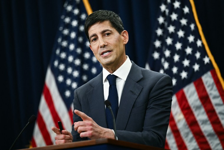 Kevin Warsh speaks while standing behind a podium