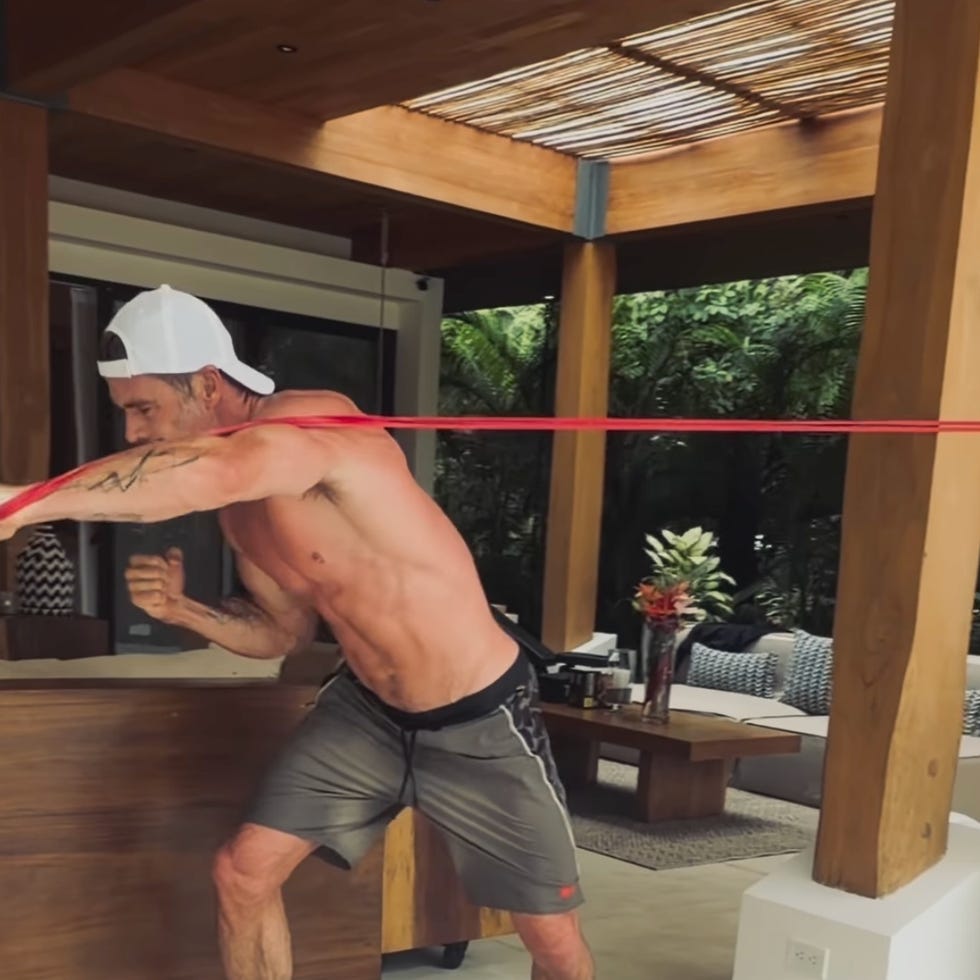 man exercising with resistance band in a wooden patio. man exercising with resistance band in a wooden patio.