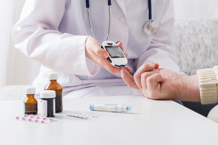 A medical worker checking a patient's blood sugar, illustrating the hidden side of hospitals for diabetics.