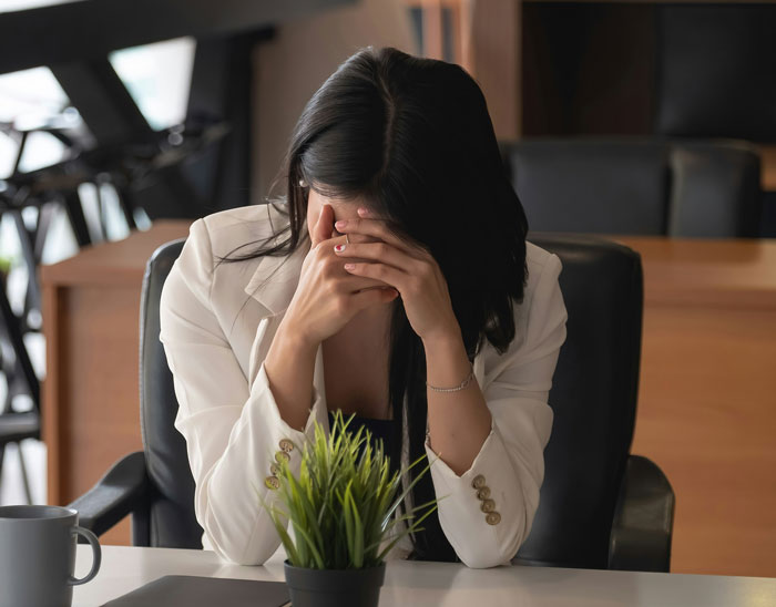 A distressed female patient with her face in her hands, failing to outsmart their doctors.