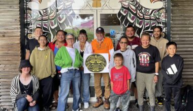 The Ha̲mdzat̓si Collective in front of the “Trials and Tribulations” mural, July 2026. (Dawn Dudek/Contributor)