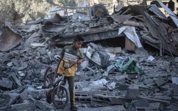 A Palestinian boy walks his bicycle through the rubble of a destroyed building after it was targeted by Israeli strikes the previous night following warnings to evacuate in Deir al-Balah, central Gaza Strip on July 29, 2026. Gaza remains gripped by daily violence, with both the Israeli military and Hamas accusing one another of violating the truce in effect since October 10. The war flattened swathes of the territory, displaced most of the population at least once, and left hundreds of thousands of people living in tents and temporary shelters. (Photo by Eyad Baba / AFP)