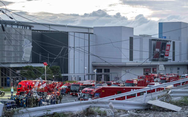 Emergency vehicles and workers are seen outside the Aeon Mall Kumamoto in Kashima, Kumamoto Prefecture, on July 29, 2026 after an earthquake struck the area. Two young women were found dead early Wednesday in a mall badly damaged by a powerful earthquake and subsequent explosion, local media reported, as crews continued searching overnight for missing people. (Photo by Yuichi YAMAZAKI / AFP)
