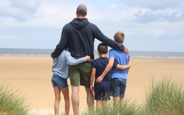 A photograph of Prince William, Prince George, Princess Charlotte and Prince Louis on the beach, taken by the Princess of Wales.