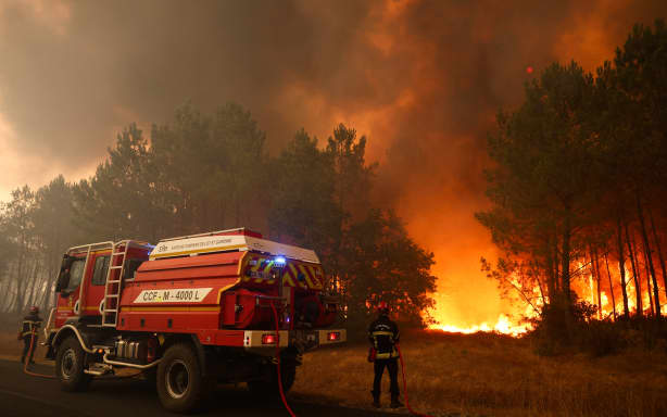 Firefighters try to extinguishing fires burning trees using a wildland water truck near Le Porge, southwestern France on 23 July, 2026.