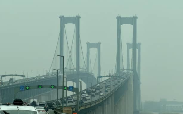 Cars travel across the Delaware Memorial Bridge as wildfire smoke from Canada causes hazy conditions, in New Castle, Delaware, on July 18, 2026. World Cup organizers said on July 17 that they were "monitoring closely" the smoke gripping swaths of the United States ahead of the tournament's weekend final in New Jersey which has been affected by dangerously unhealthy air. (Photo by Daniel SLIM / AFP)