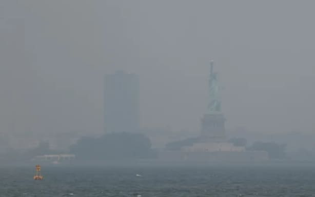 Haze from Canadian wildfires blankets the Statue of Liberty, as seen from a Brooklyn pier in New York on July 15, 2026. Spencer Platt/Getty Images