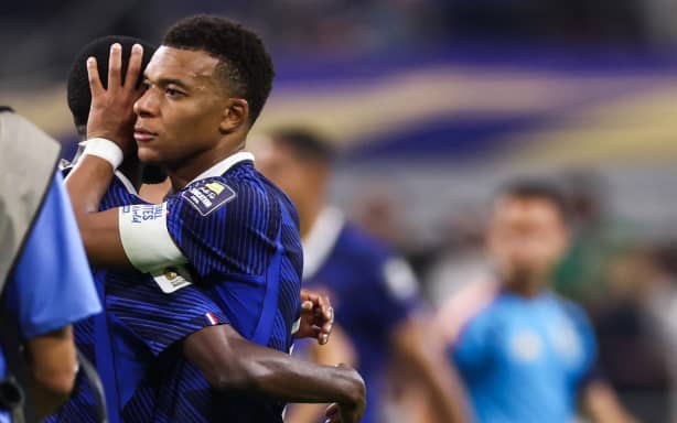 France's forward #10 Kylian Mbappe hugs a teammate after losing the 2026 World Cup football tournament semi-final match between France and Spain at the Dallas Stadium in Arlington on July 14, 2026.  (Photo by FRANCK FIFE / AFP)