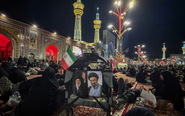 People wait at Imam Reza's shrine for the funeral of slain Iranian leader Ali Khamenei and members of his family in Mashhad early on July 9, 2026. Iranians were preparing on July 9 to bury their slain leader Ali Khamenei in his hometown of Mashhad in northeast Iran, as new US strikes threatened to trigger a fresh escalation in the Middle East war. The late supreme leader's burial follows a multi-day funeral ceremony that attracted millions of mourners across various cities in both Iran and Iraq. (Photo by ATTA KENARE / AFP) /