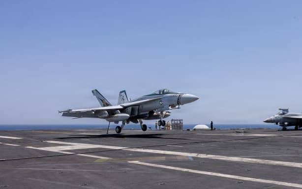 This US Navy handout photo released on May 6, 2026 by US Central Command Public Affairs shows an F/A-18E Super Hornet landing aboard Nimitz-class aircraft carrier USS George H.W. Bush (CVN 77) at sea on April 27, 2026. The United States has completed its offensive operations against Iran, Secretary of State Marco Rubio said on May 5, even as Washington warned it was ready to unleash a "devastating" response to any new attacks on shipping in the Strait of Hormuz. Rubio's remarks came after Washington's top military officer said American forces remain ready to resume combat operations if ordered, as clashes in the vital waterway threatened to unravel a fragile ceasefire. (Photo by US NAVY / AFP) / RESTRICTED TO EDITORIAL USE - MANDATORY CREDIT "AFP PHOTO / US NAVY / NAVCENT PUBLIC AFFAIRS" - HANDOUT - NO MARKETING NO ADVERTISING CAMPAIGNS - DISTRIBUTED AS A SERVICE TO CLIENTS