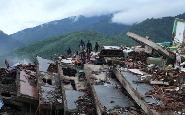 Residents search through the rubble of a building that collapsed in the earthquakes in La Guaira, Venezuela, on Tuesday, 30 June.