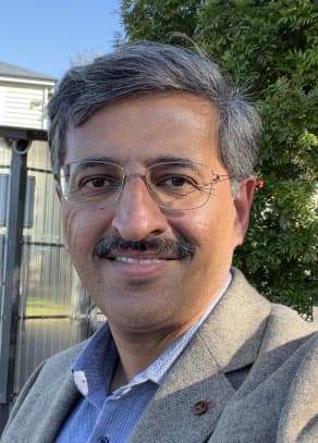 Head and shoulders shot of man with  moutache and glasses