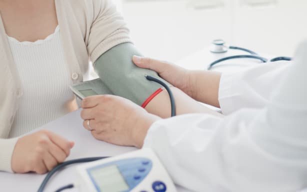 Doctor measures blood pressure of patient.