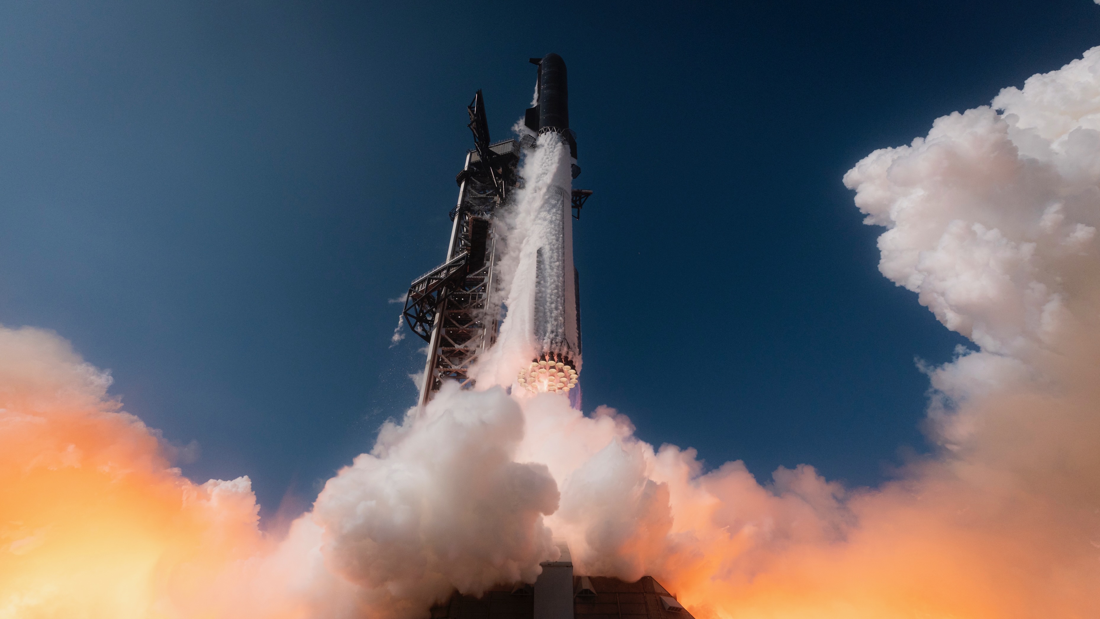 ground-level view of a huge silver and black rocket lifting off