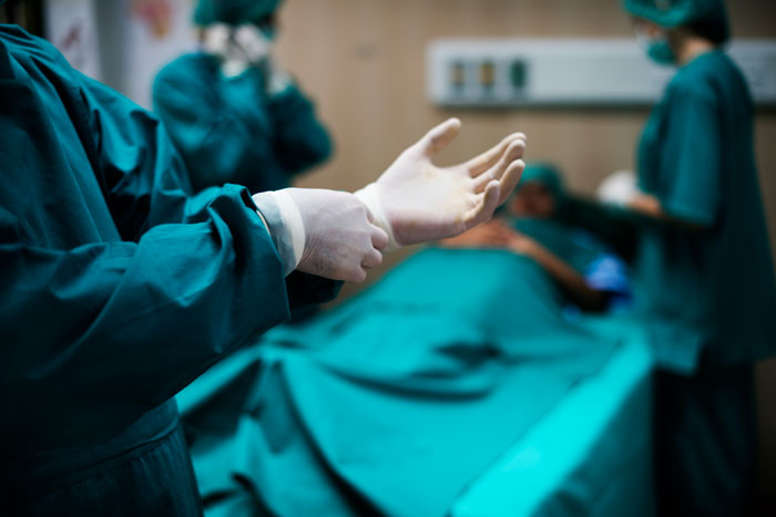 Medical workers preparing for surgery in a hospital operating room, highlighting the hidden side of hospitals.