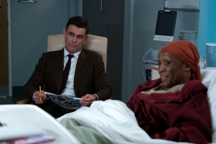 566698,TITLE:Eastenders Jack sits beside Denise in a hospital bed in EastEnders