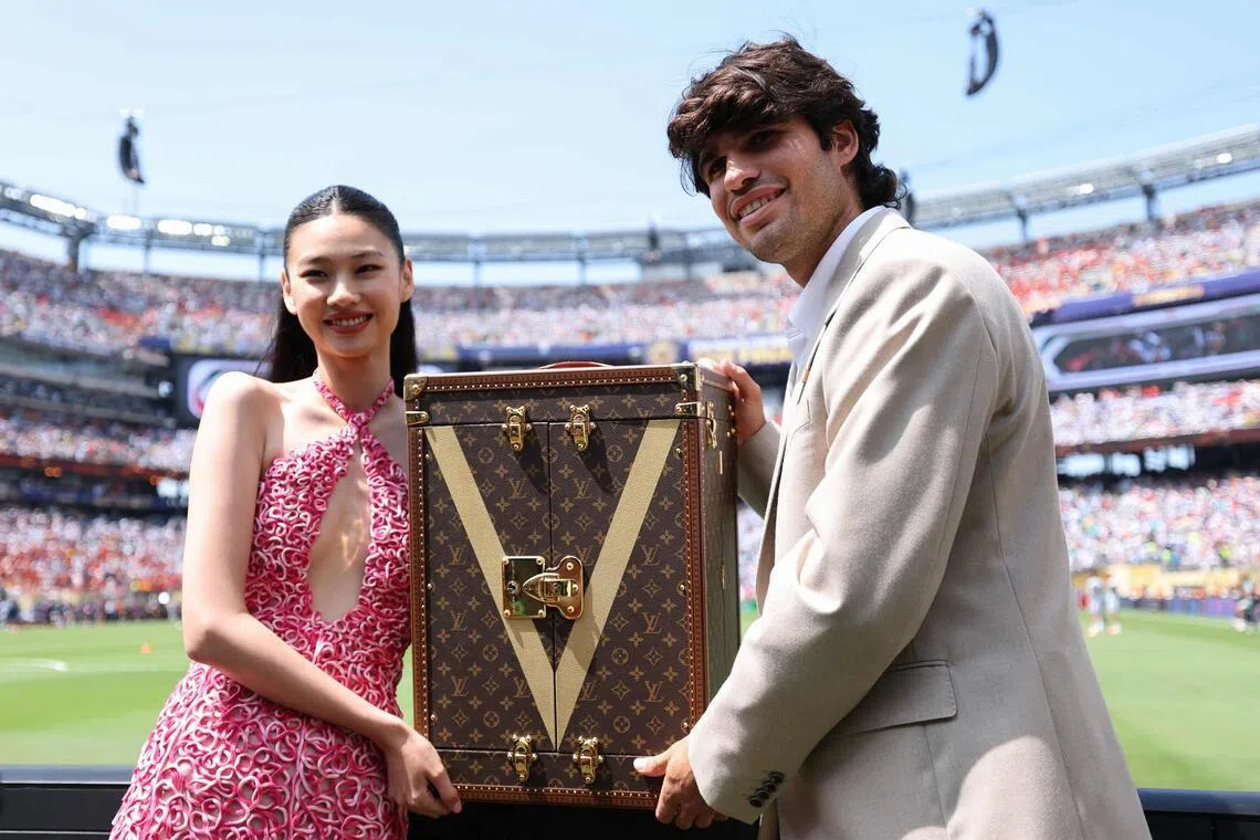 South Korean actress Hoyeon (left) was joined by Spanish tennis star Carlos Alcaraz as the pair carried the World Cup trophy in a specially designed Louis Vuitton case.