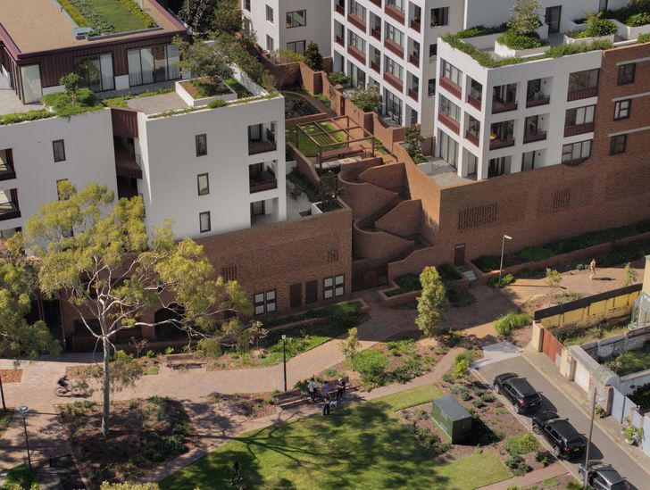 The site massing comprises two perimeter blocks running north-south, with a shared central garden.