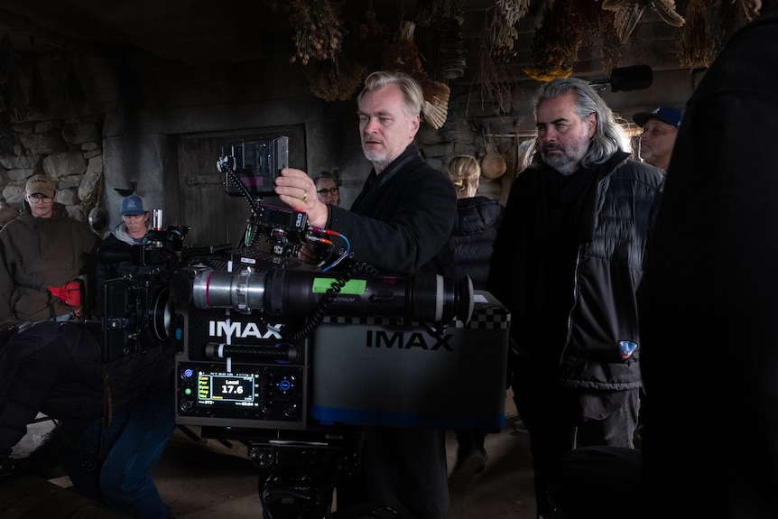 Christopher Nolan on set behind an IMAX camera