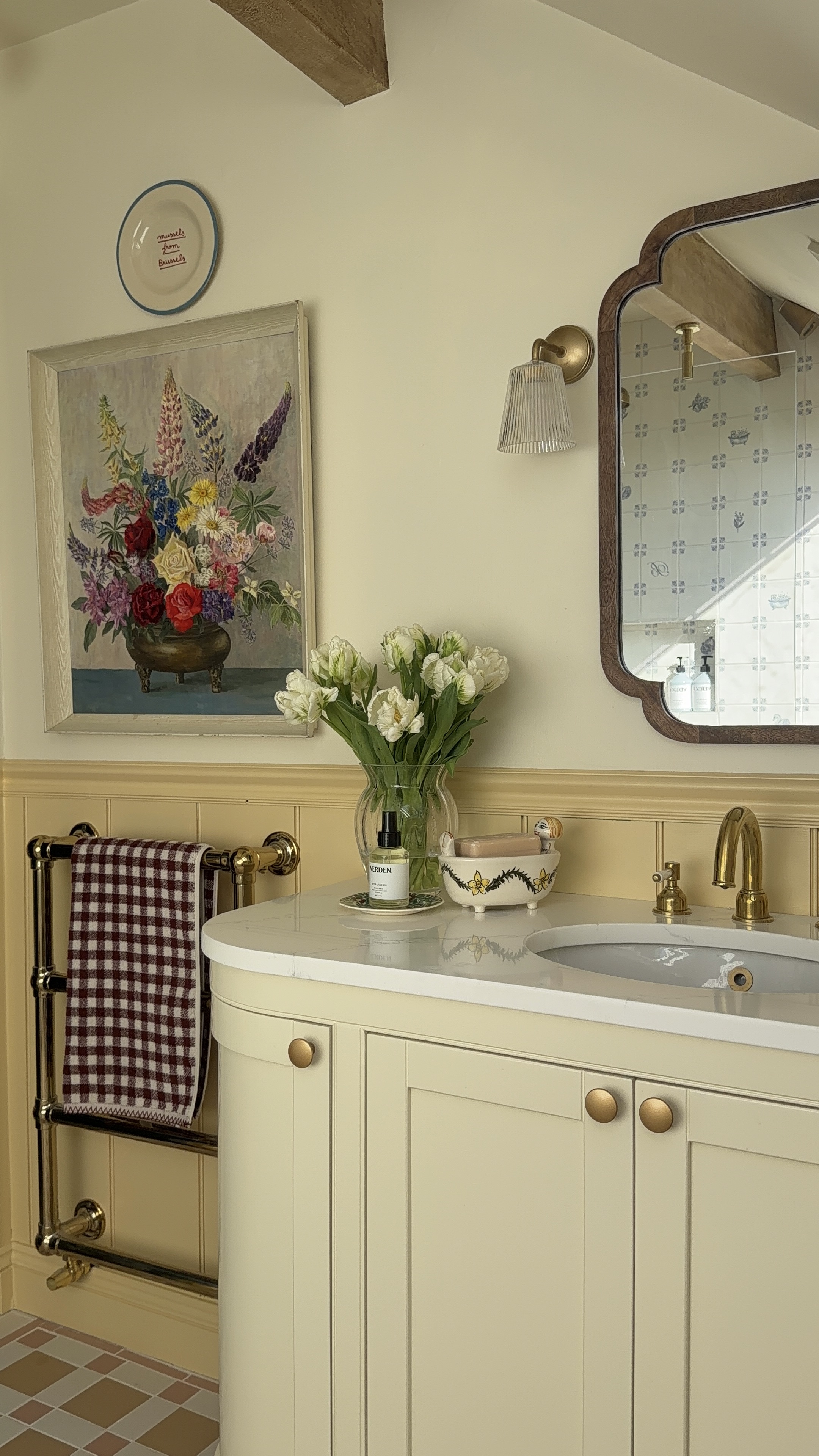 butter yellow bathroom with gold hardware and vintage touches throughout