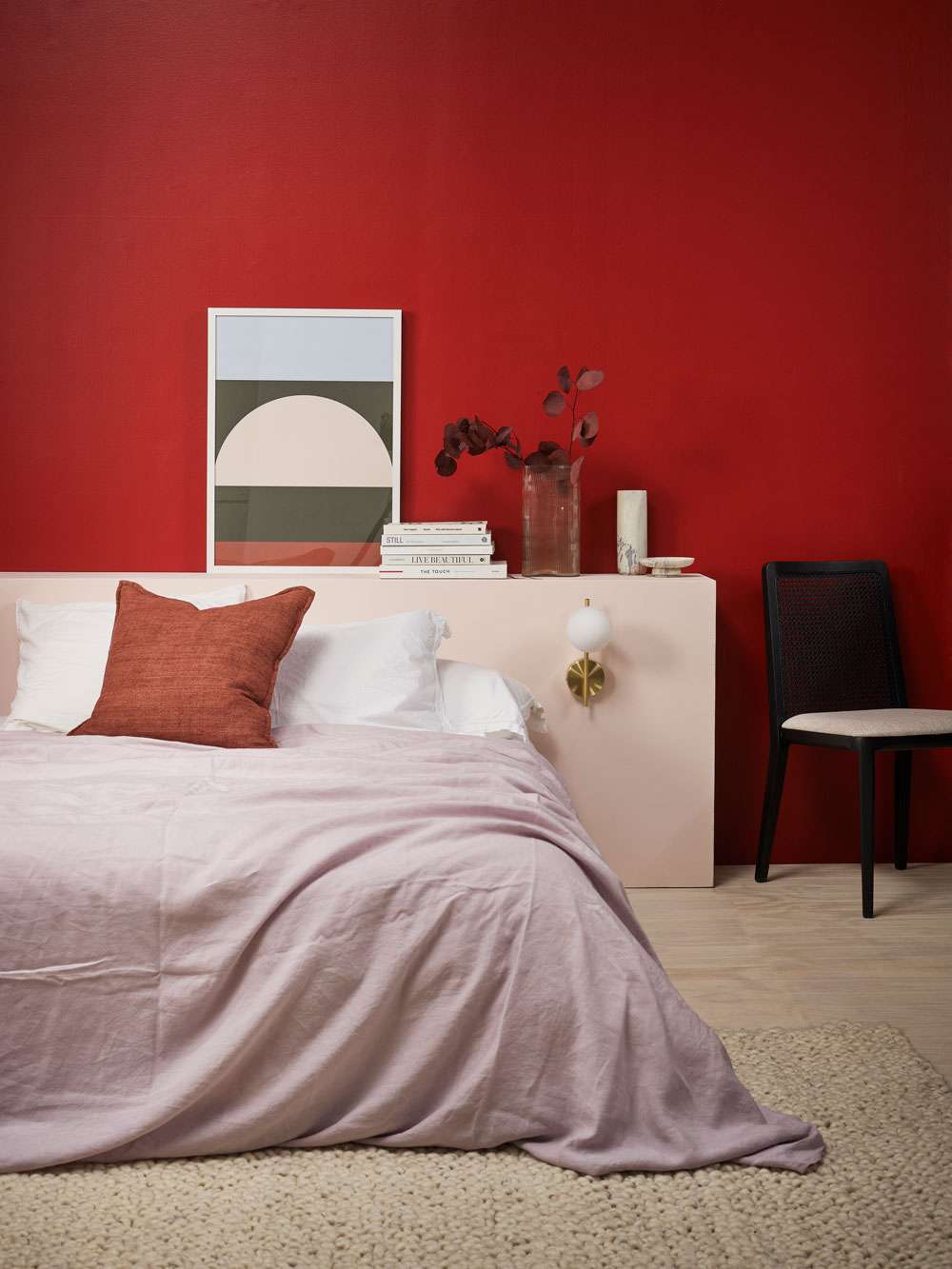 Keeping rooms uncluttered and simple allows the red to shine rather than compete. Wall and planter in Resene Lonestar, floor and vase in Cinder, mask decor in Vesuvius. Chair from Good Form, rug from Baya. Project Amber Armitage. Image Wendy Fenwick.