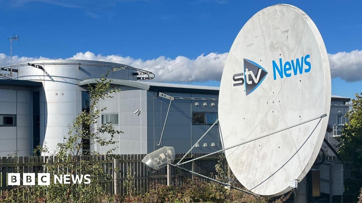 STV News headquarters featuring a large satellite dish, modern architecture, and a clear blue sky with scattered clouds.