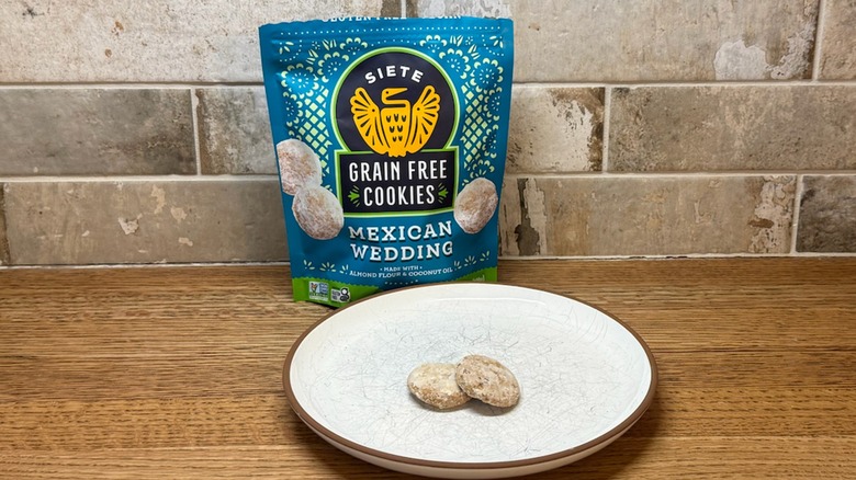 A bag of Siete Mexican Wedding Cookies on a counter with two cookies displayed on a white plate in front