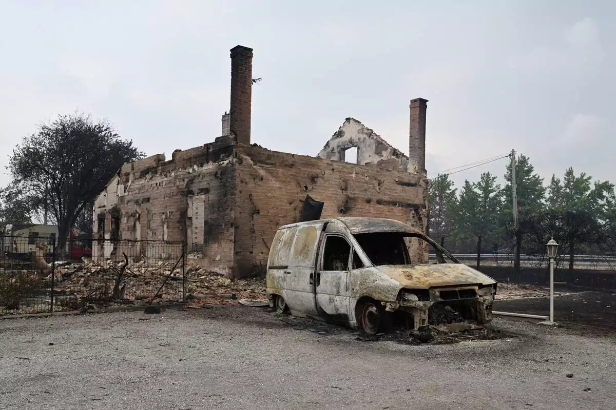 A view of a burned house and vehicle, in Lanton, in the Lege-Cap-Ferret region, southwestern France, Saturday, July 25, 2026. (AP Photo/Emma Da Silva)