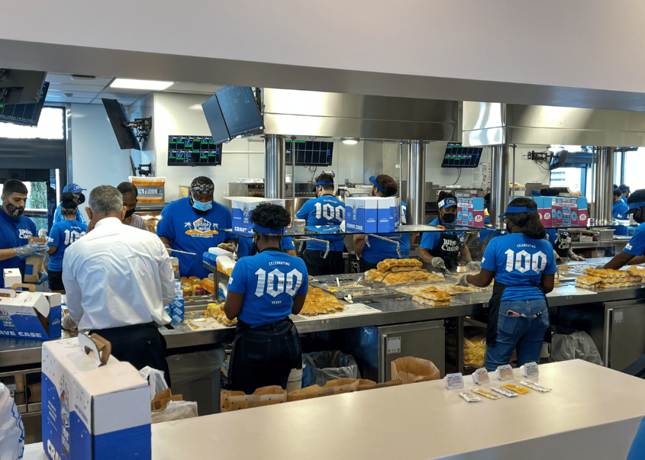 Employees making burgers inside a White Castle. -