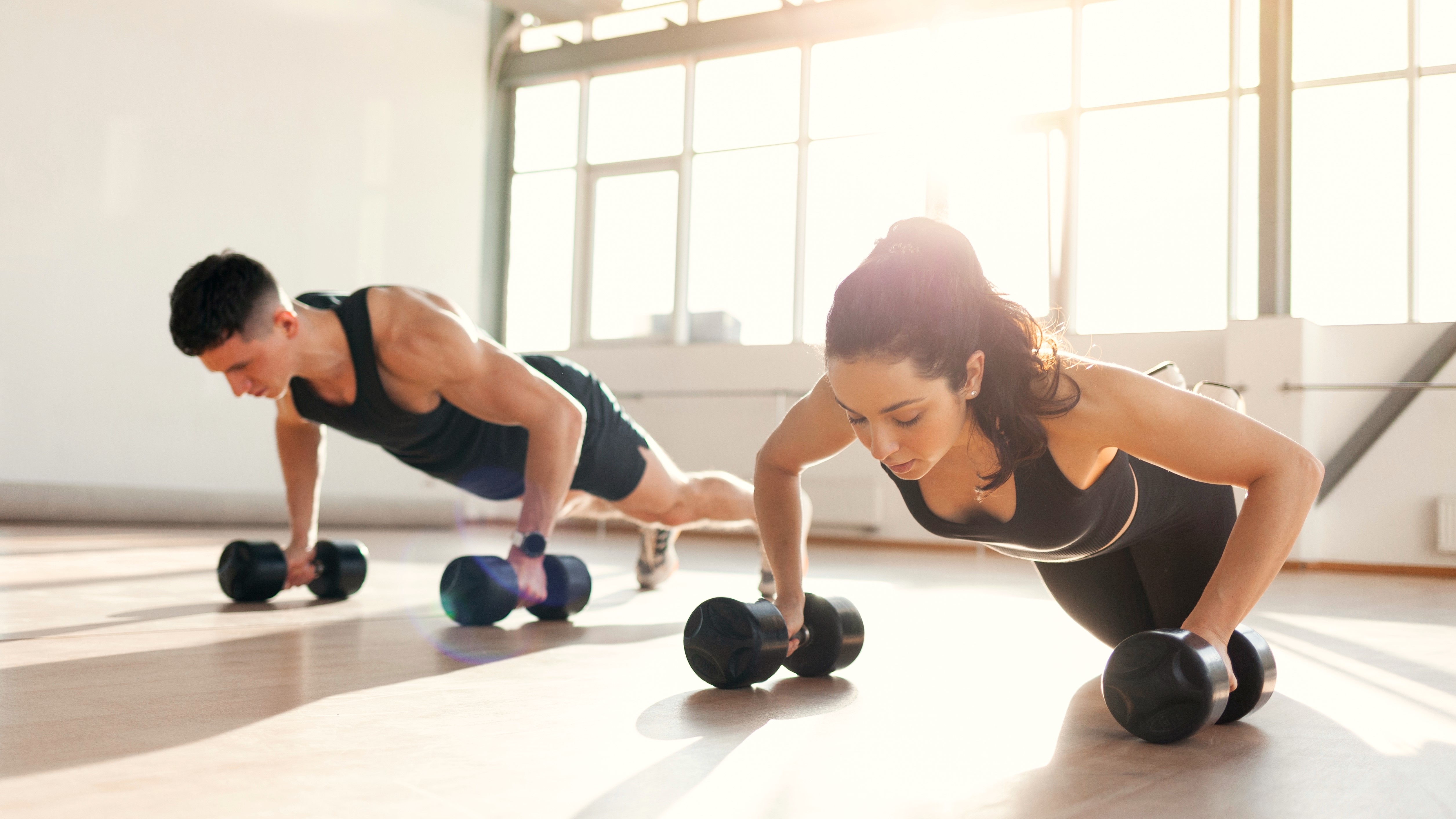 a photo of a couple doing dumbbell push ups