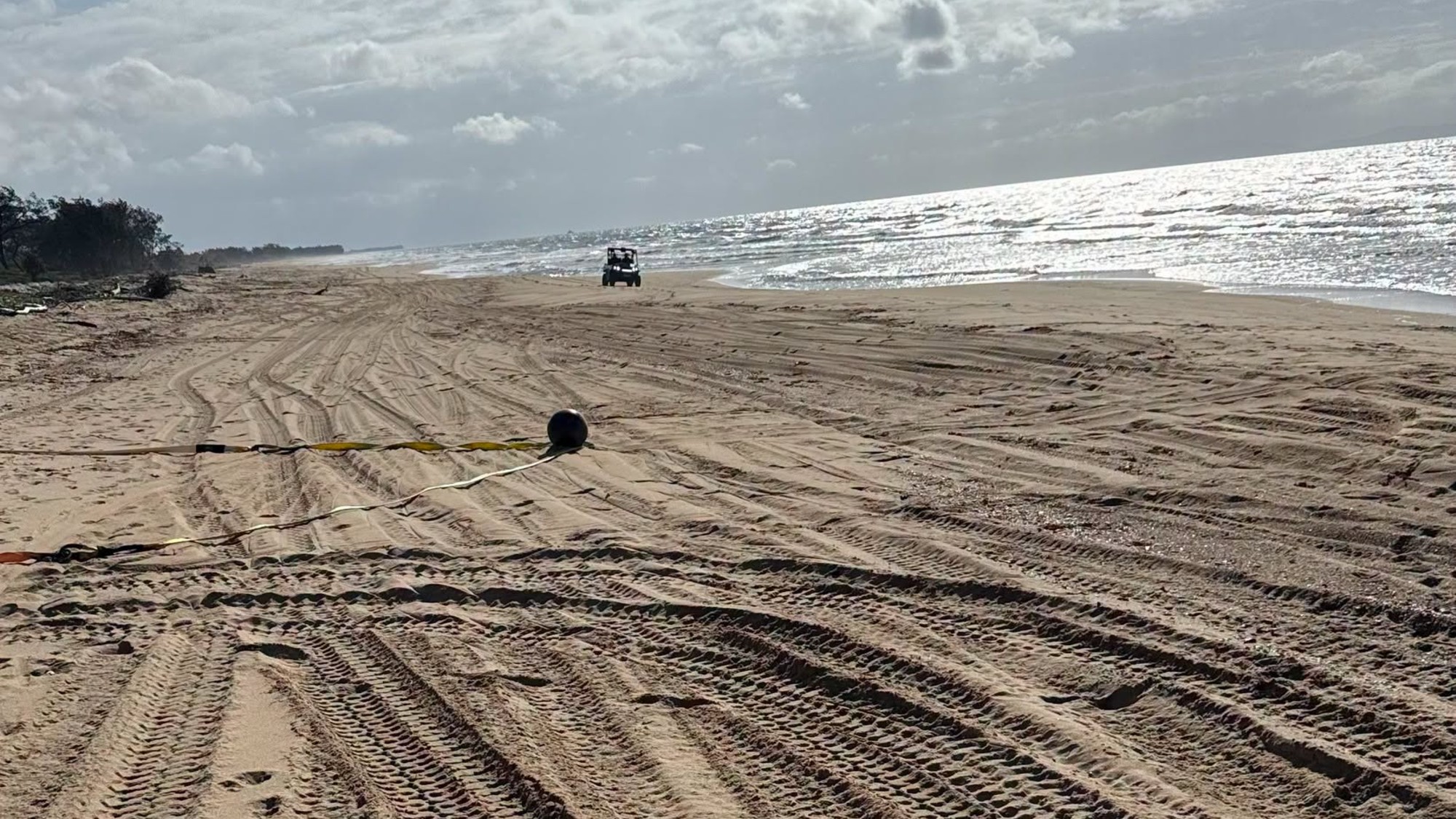 a metallic sphere on a sandy beach