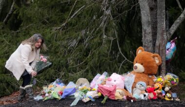 An unidentified woman left flowers at a makeshift shrine in front of the home of Lindsay Clancy, who is charged with murdering her three children, in January 2023.