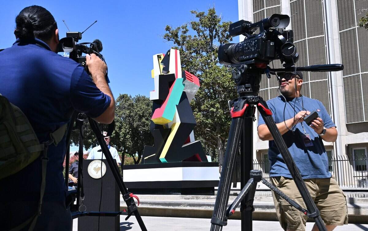 Media gathers to cover the newly restored statue Dos Amantes, located on the Mariposa Mall, in a brief ceremony Tuesday, July 28, 2026 in downtown Fresno.
