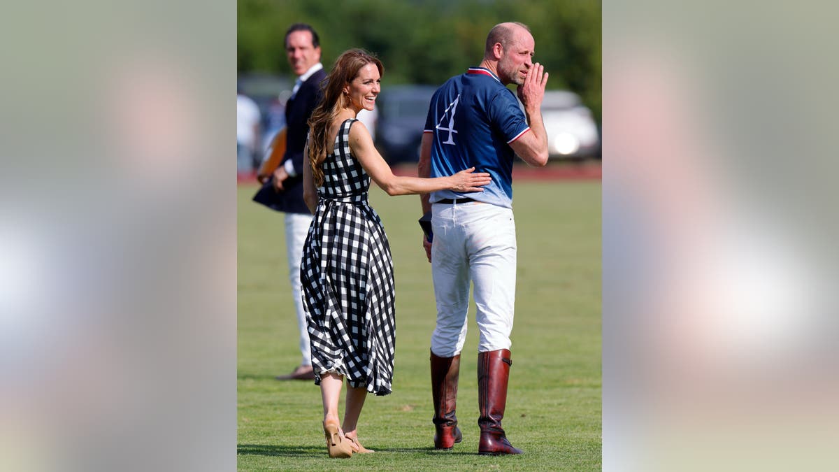 Catherine, Princess of Wales stands with Prince William at a polo match in Windsor, England.